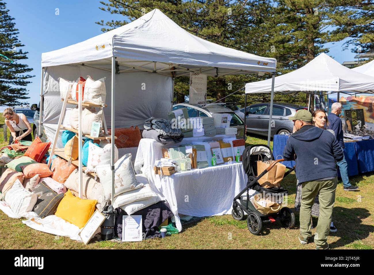 Market stall and vendor at Palm Beach market day on Sydney northern beaches selling pillows and cushions NSW,Australia winter 2022 Stock Photo