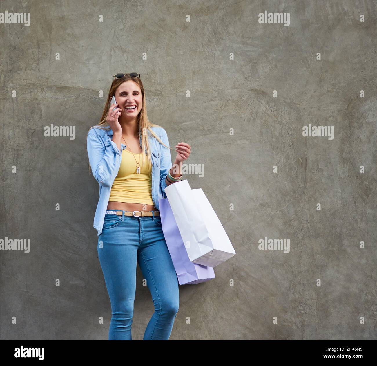 I just wanted to tell you about this great sale...an attractive young woman talking on a cellphone while shopping in the city. Stock Photo