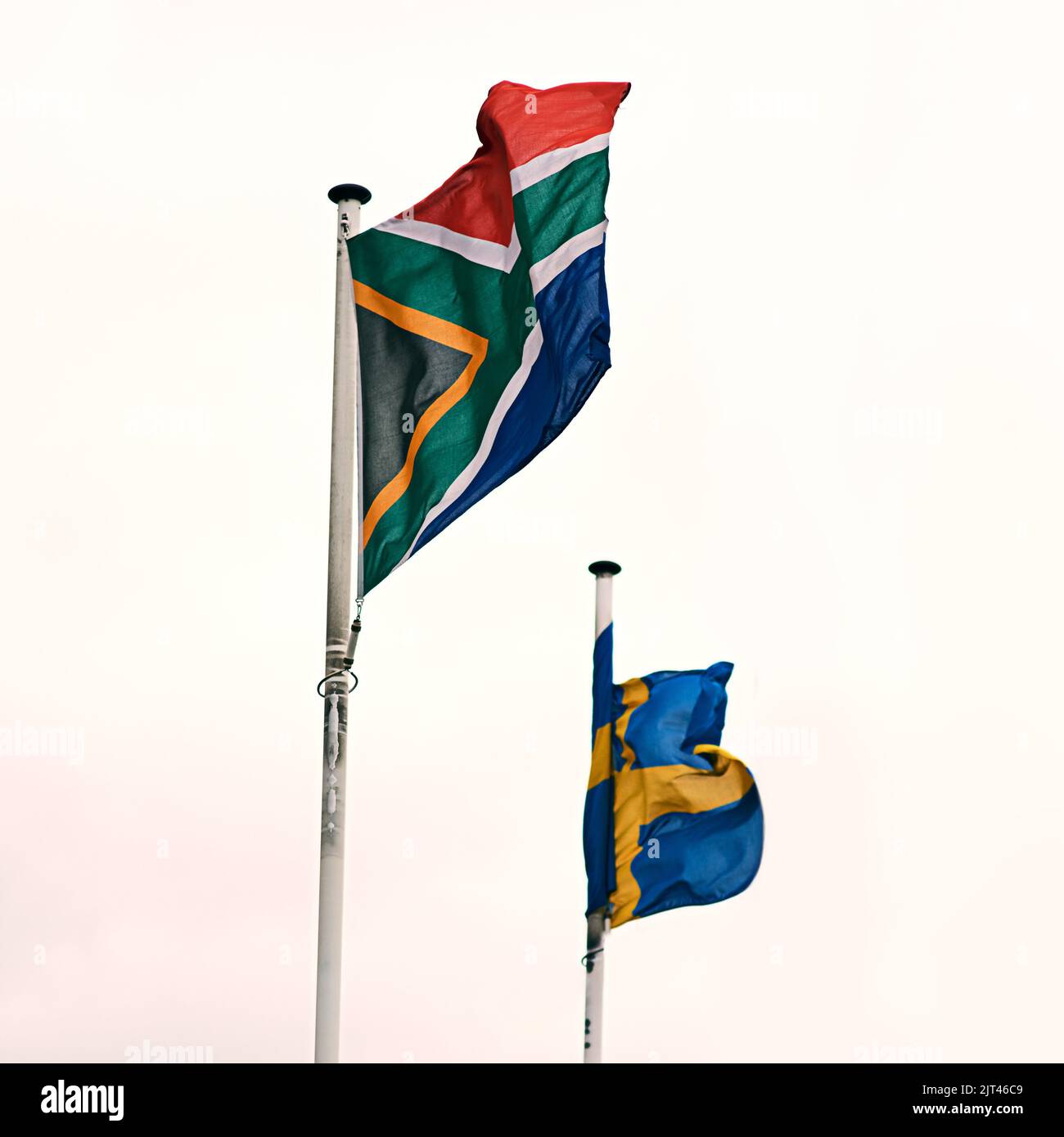 Flying side by side. the South African and Swedish flags blowing in the wind. Stock Photo