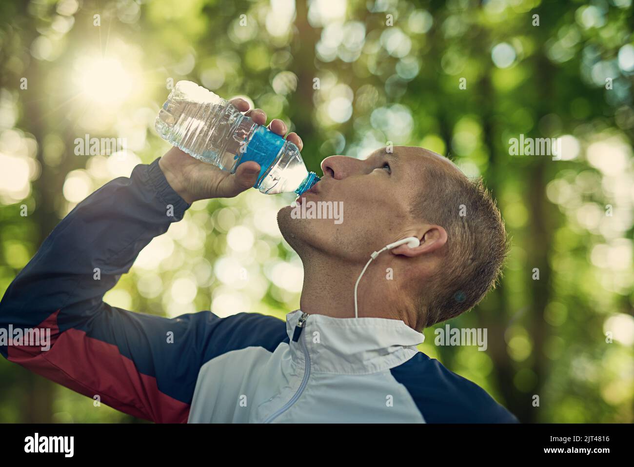 Hydration is key. a man taking a break to drink some water while out