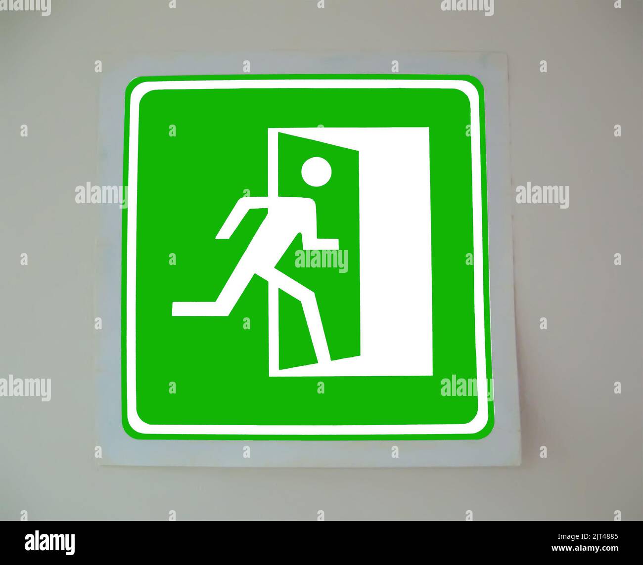 green exit emergency sign with door direction on the wall, evacuation