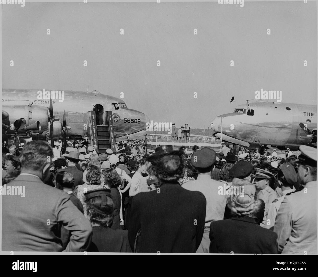 Two airplanes and a crowd assembled for the christening by Bess Truman