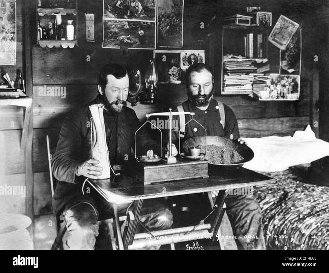 Two miners weighing gold in cabin, ca 1900 Stock Photo - Alamy