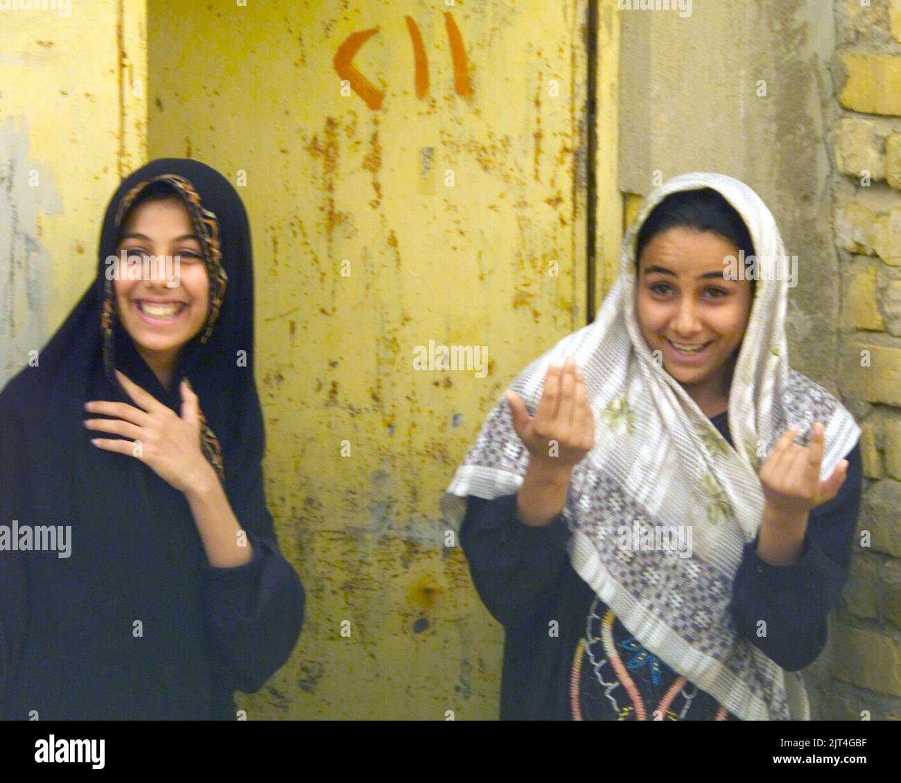 Two young local women communicate with US Marine Corps (USMC) cameraman