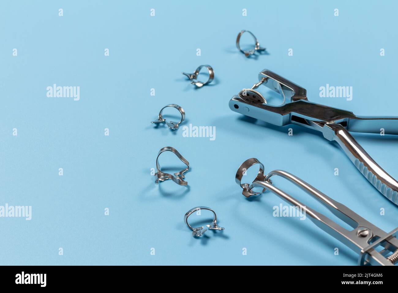Dental hole punch, the rubber dam forceps and the clamps on the blue