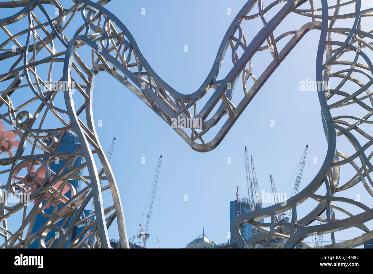 Construction cranes framed by public art in Melbourne's CBD. Stock Photo