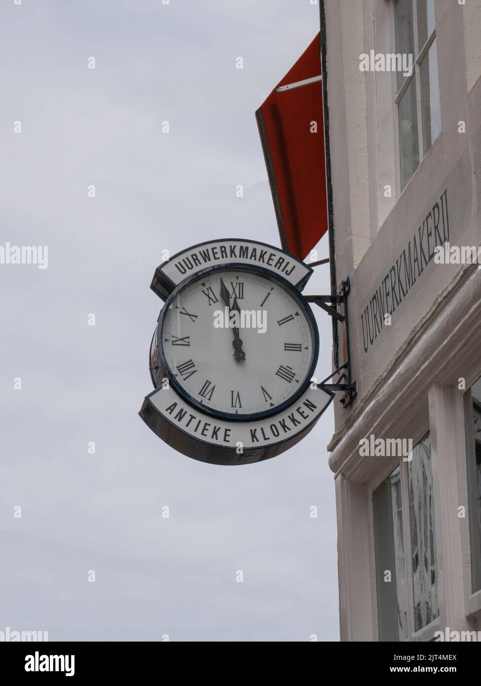 Signboard on a facade of a shop with the inscription, clockwork and antique clocks Stock Photo