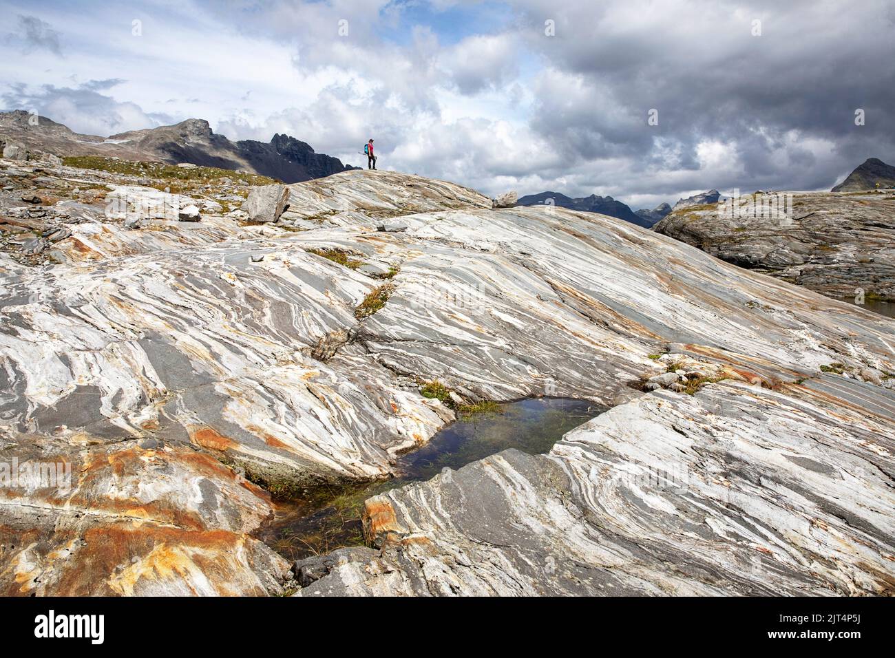 Woman hiking over colorful rocks on a glacier moraine on a beautiful Innergschlöss Glacier Trail to Schlatenkees glacier, East Tyrol, Austria Stock Photo