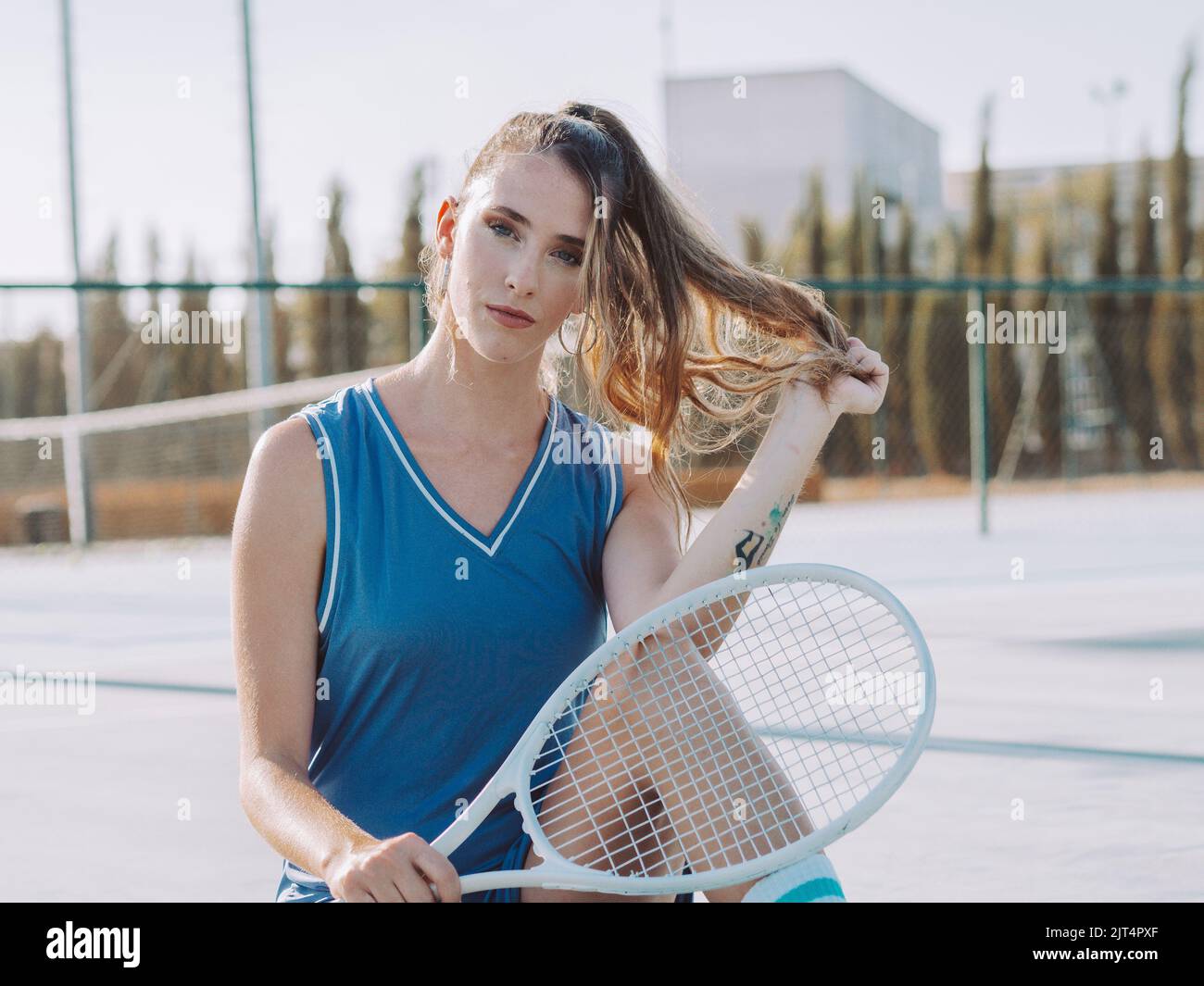 Photo Poses With Racket A young female with racket posing on tennis court Stock Photo - Alamy