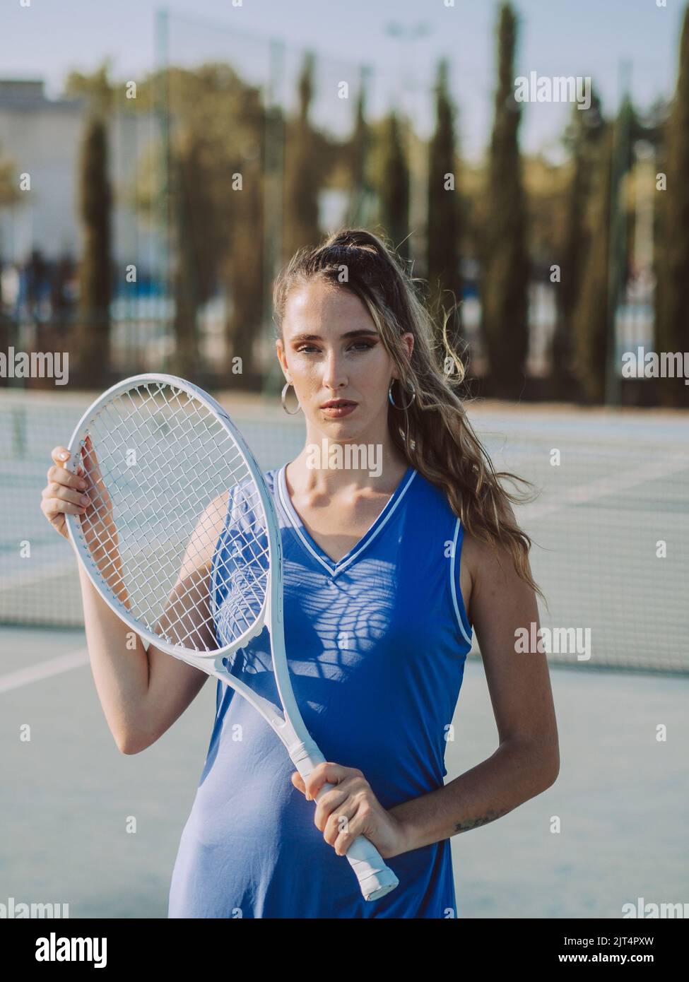 Photo Poses With Racket A young female with racket posing on tennis court Stock Photo - Alamy