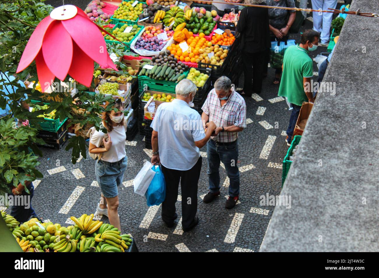 A high-angle shot of people doing transactions at a local market Stock Photo