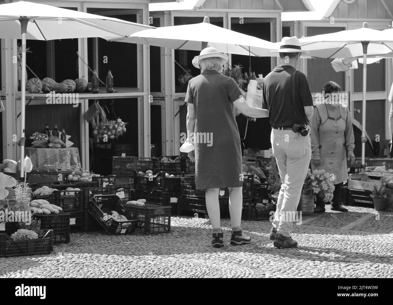 A grayscale shot of two people walking at a local market in Ikast, Denmark Stock Photo