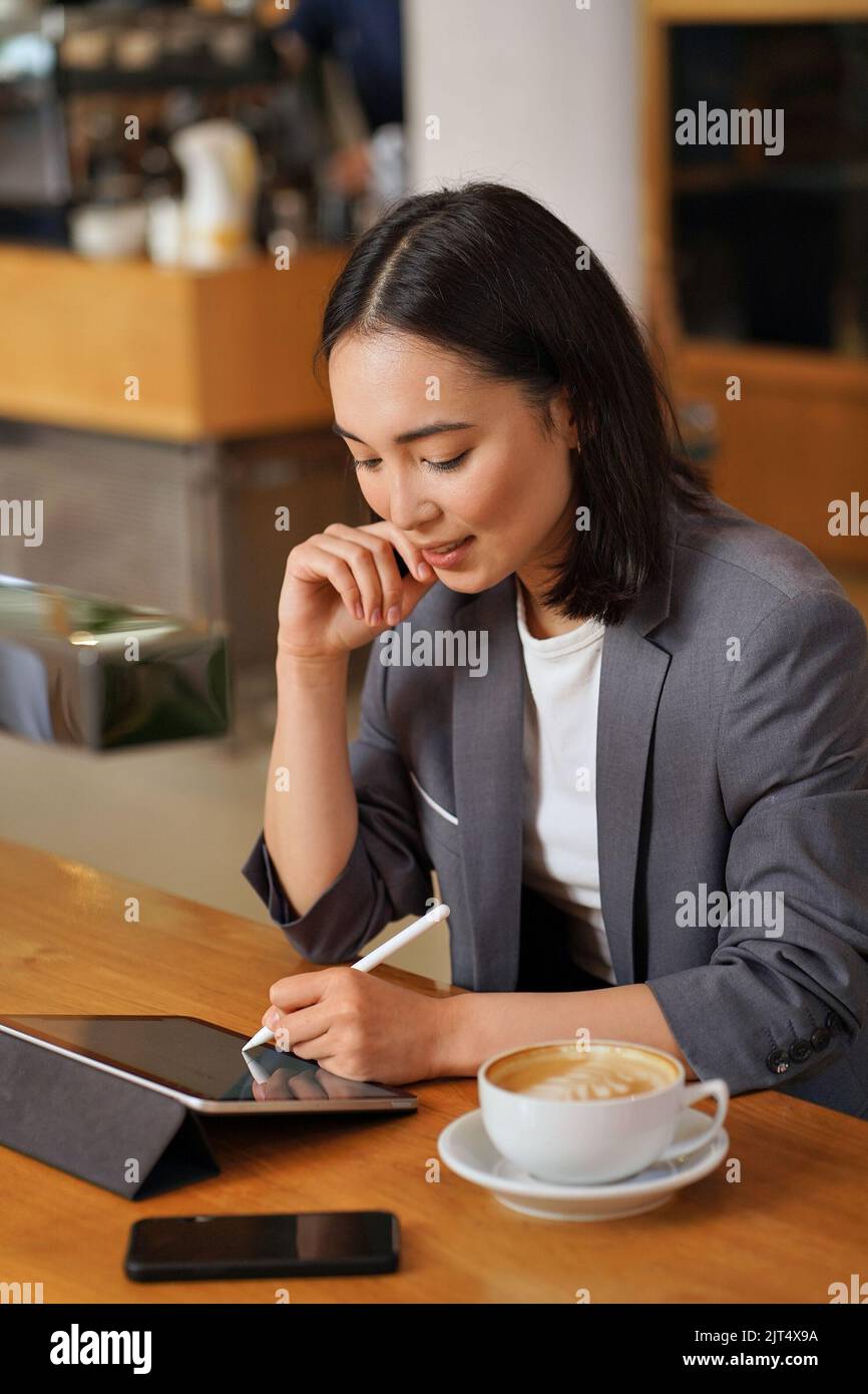 Young Asian business woman using digital tablet writing e signature. Stock Photo