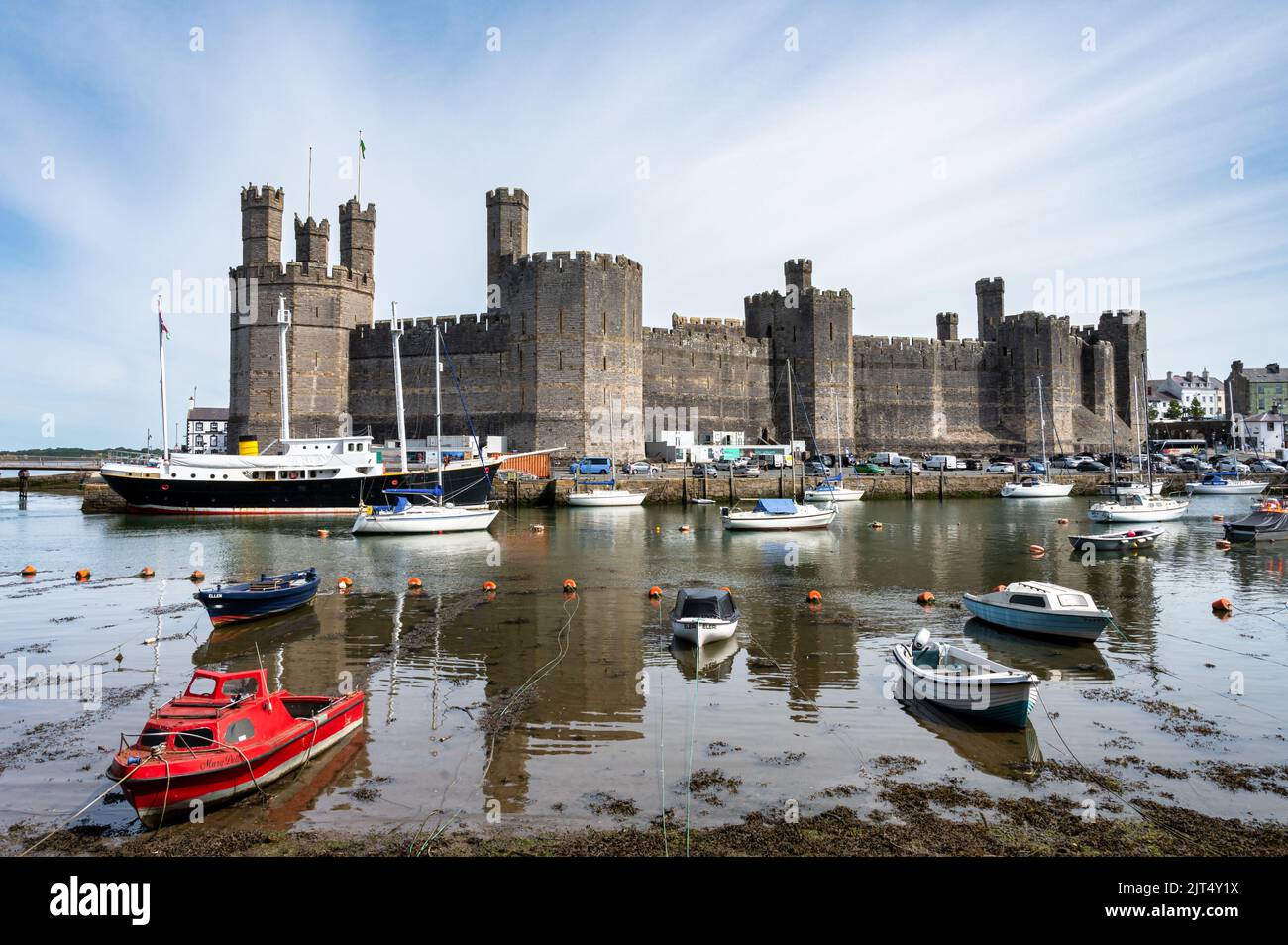 Caernarfon, UK- July 11, 2022: Fishing boats on the river Seiont in front of the medieval Castle at Caernarfon in North Wales Stock Photo