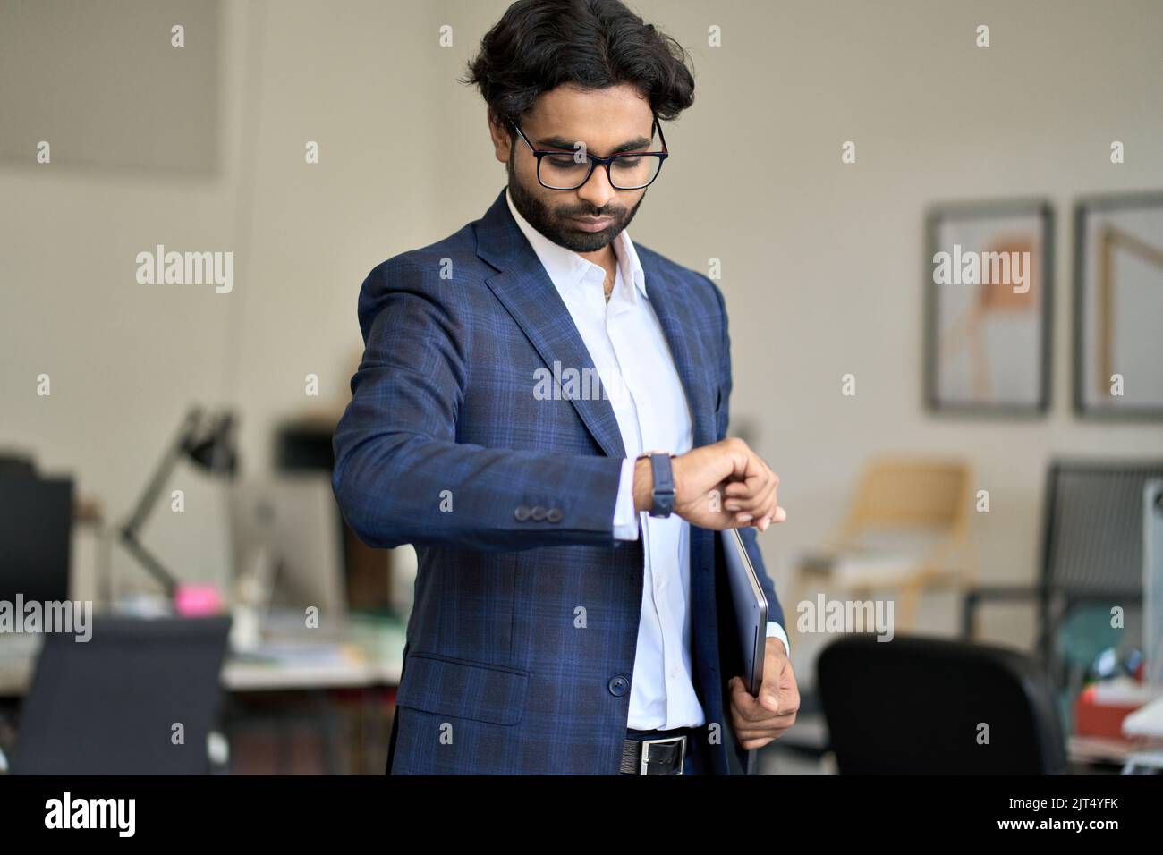 Busy indian business man checking time looking at watch in office. Stock Photo