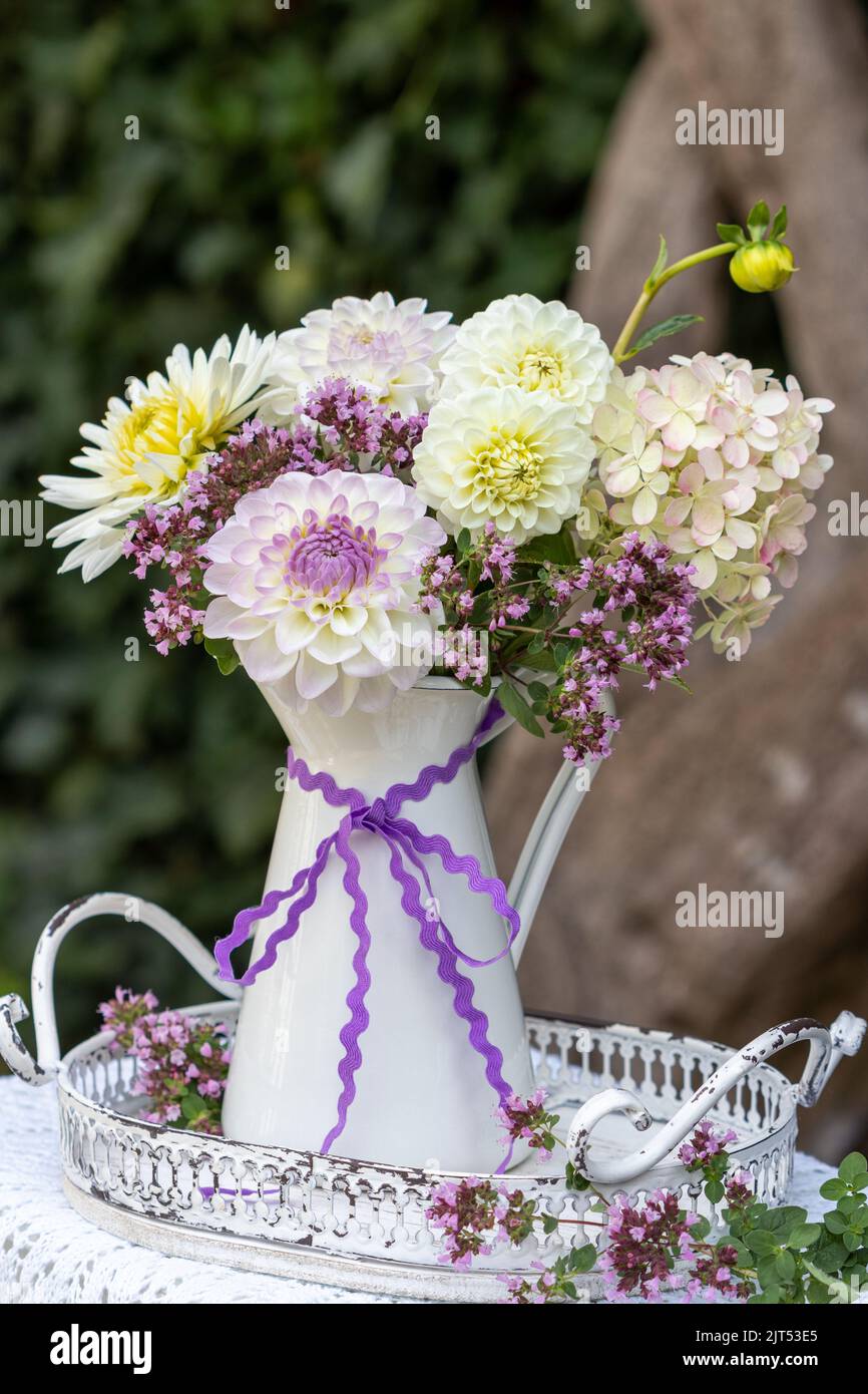bouquet of white and purple dahlias, hydrangea flowers and wild thyme in vintage jug Stock Photo