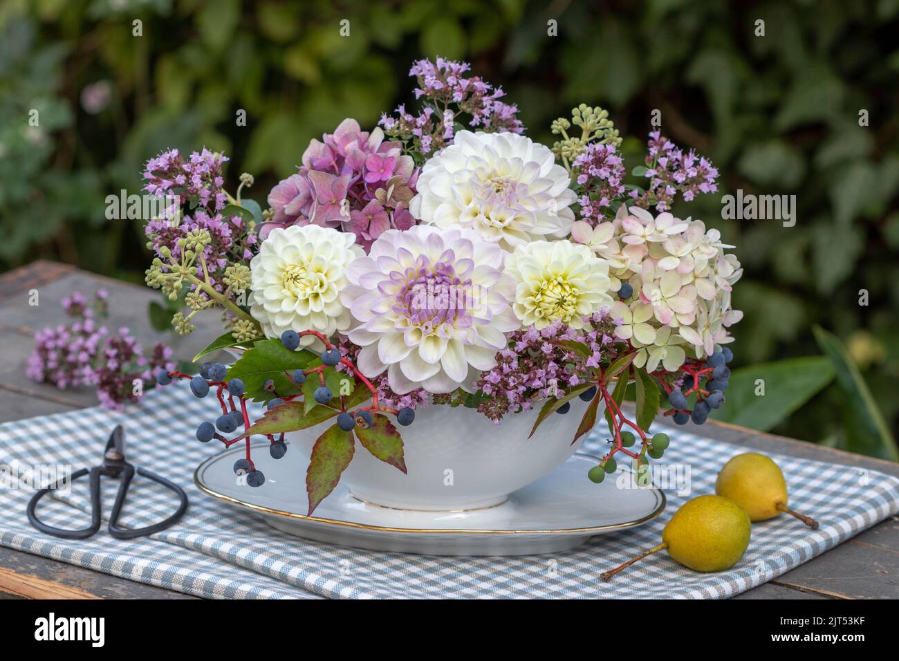 floral arrangement with white and purple dahlias, hydrangea flowers and wild thyme in vintage sauciere Stock Photo