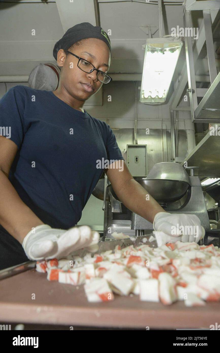 U.S. Navy Culinary Specialist Seaman Recruit chops seafood in the