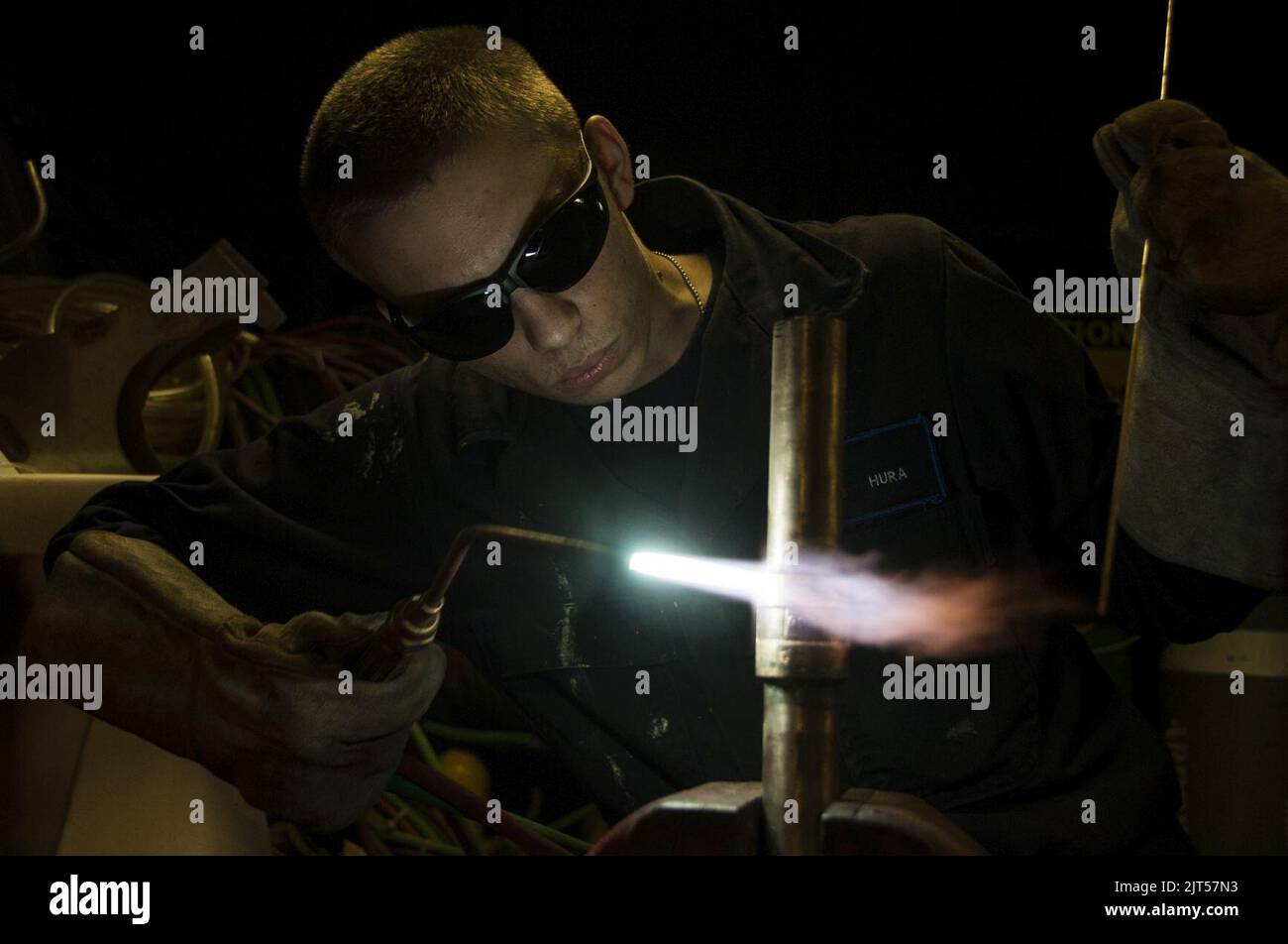 U.S. Navy Hull Maintenance Technician Fireman fabricates a pipe on the aircraft carrier USS George H.W. Bush (CVN 77) in the Persian Gulf Oct. 20, 2014 141020 Stock Photo