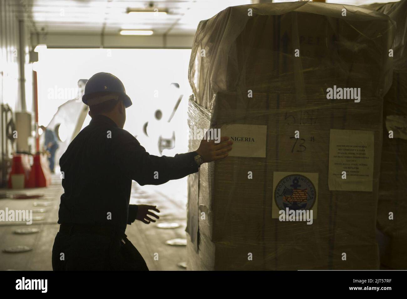 U.S. Navy Intelligence Specialist 3rd Class helps unload goodwill