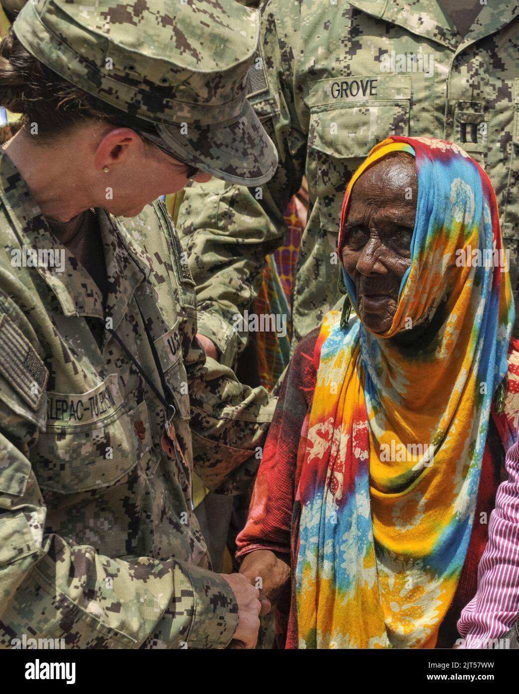 U.S. Navy Lt. Cmdr. left, the officer in charge of the expeditionary medical facility at Camp Lemonnier, Djibouti, exchanges greetings with a Djiboutian woman at the home of a community 140409 Stock Photo