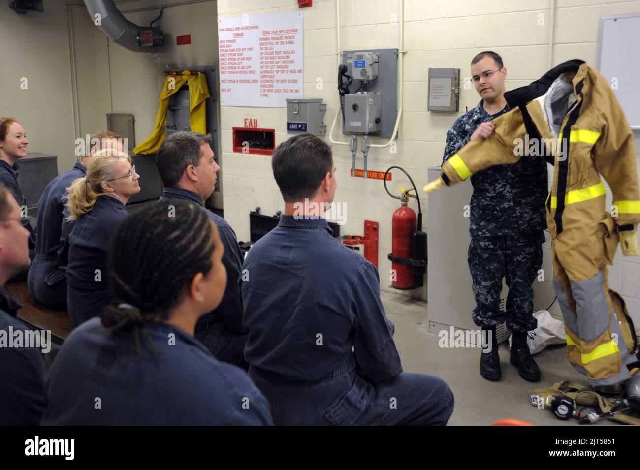 U.S. Navy Machinist's Mate 2nd Class right, shows a firefighting