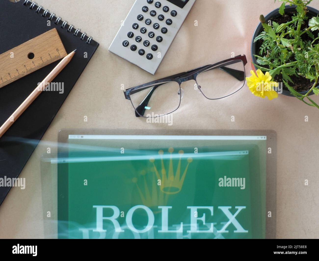 In this photo illustration,  Rolex SA logo seen displayed on a tablet Stock Photo