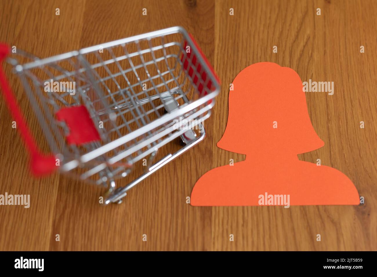 A shopping cart on a wooden table with a sticker icon Stock Photo