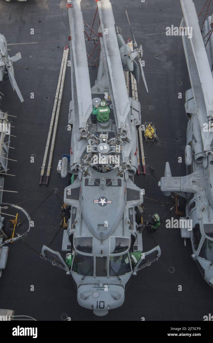 U.S. Sailors perform maintenance on an MH-60S Seahawk helicopter assigned to Helicopter Sea Combat Squadron (HSC) 7 aboard the aircraft carrier USS Harry S. Truman (CVN 75) in the U.S. 5th Fleet area 140305 Stock Photo