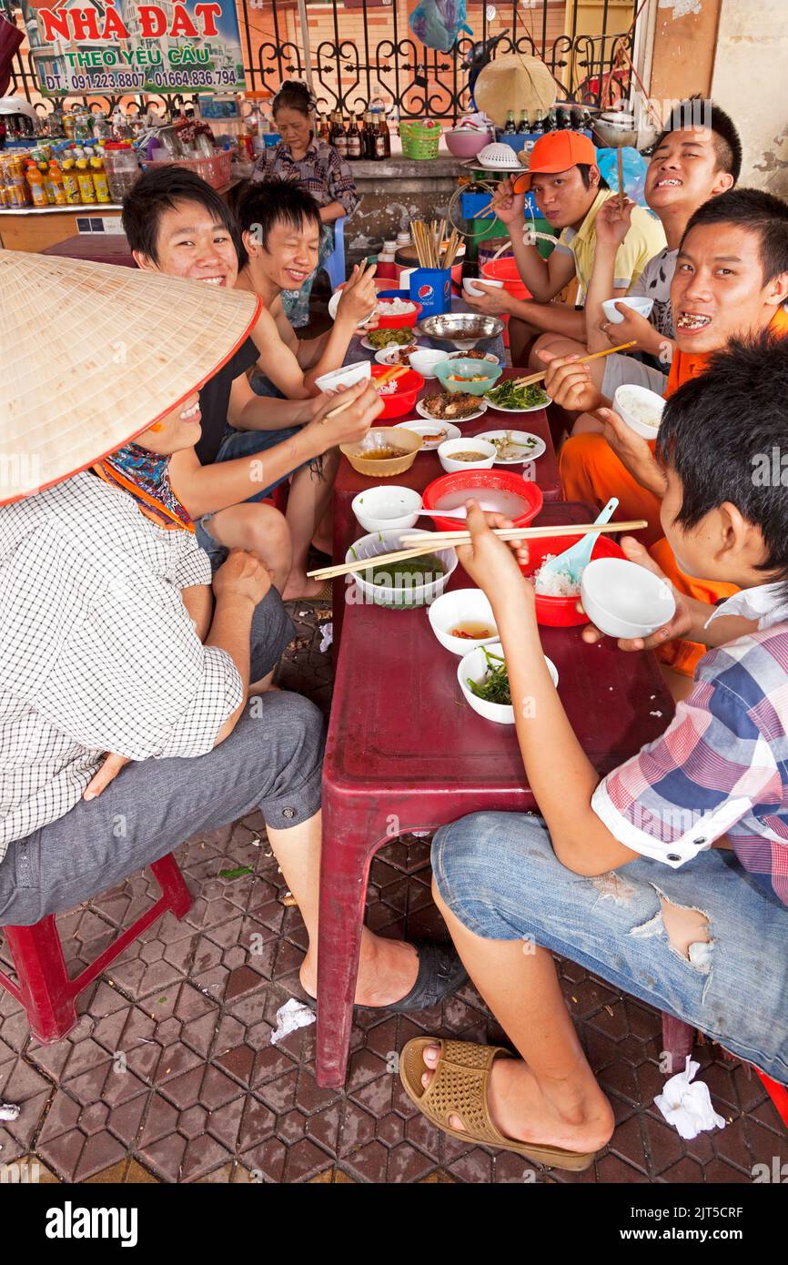 Vietnamese people eating at open air restaurant in the street, Hai Phong, Vietnam Stock Photo