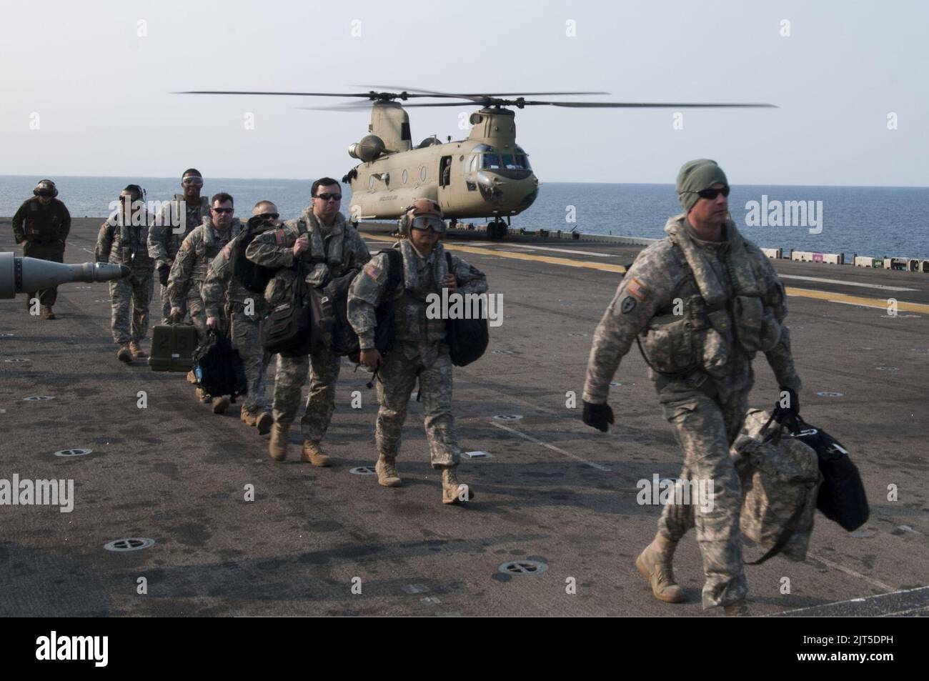 U.S. Soldiers assigned to the 3rd General Support Aviation Battalion, 2nd Combat Aviation Brigade, 2nd Infantry Division disembark from an Army CH-47F Chinook helicopter on the flight deck of the amphibious 140411 Stock Photo