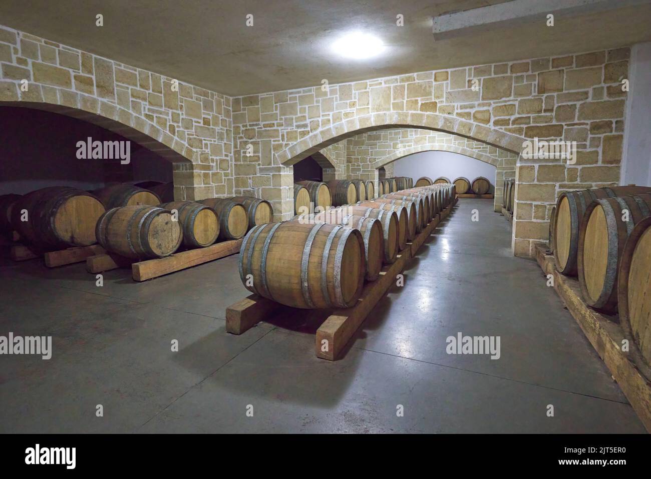Old Wooden barrels with wine in a wine vault in Crete - Greece Stock Photo