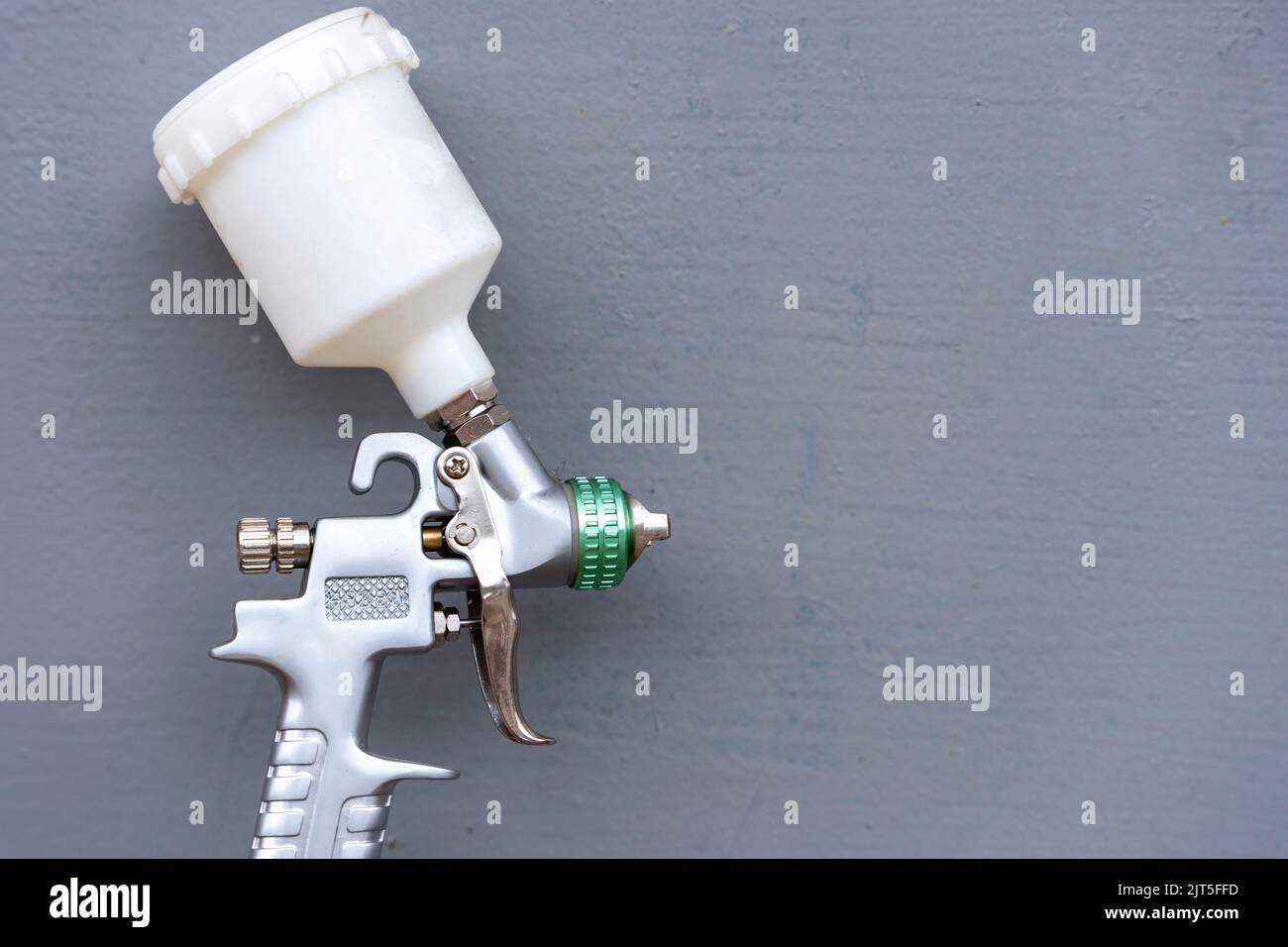 Paint spray gun for painting on a gray background. Auto and moto repair