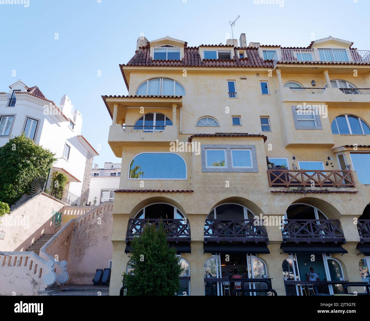 Yellow multi layered building with balconies in the town of Cascais, district of Lisbon, Portugal. Stock Photo