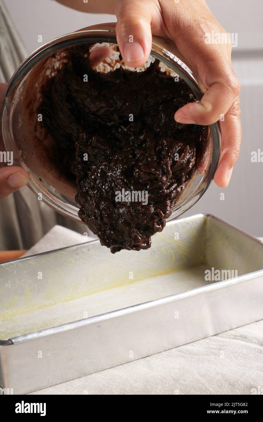Pour Brownie Cake Batter to the Baking Pan, Female Hand Action Shoot Stock Photo