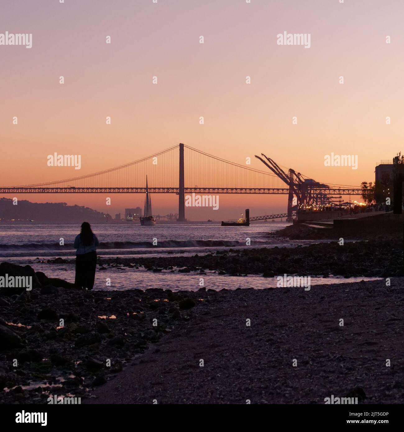 Sunset over the Ponte 25 de Abril bridge in Lisbon as seen from Lisbon  beach, Portugal Stock Photo - Alamy