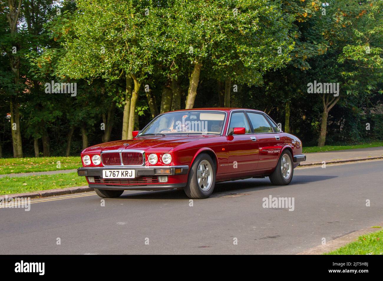 1994 90s nineties British JAGUAR Red XJ Gold 3239cc petrol 4 speed automatic; arriving at The annual Stanley Park Classic Car Show in the Italian Gardens. Stanley Park classics yesteryear Motor Show Hosted By Blackpool Vintage Vehicle Preservation Group, UK. Stock Photo