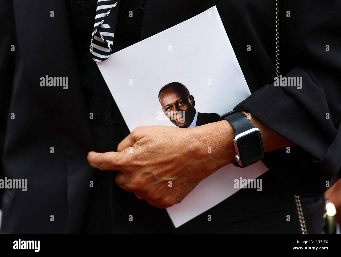 A mourner arrives holding a funeral programme during the funeral of Angola's former President Jose Eduardo dos Santos, who died in Spain in July, at the Agostinho Neto Memorial, in Luanda, Angola, August 28, 2022. REUTERS/Siphiwe Sibeko Stock Photo