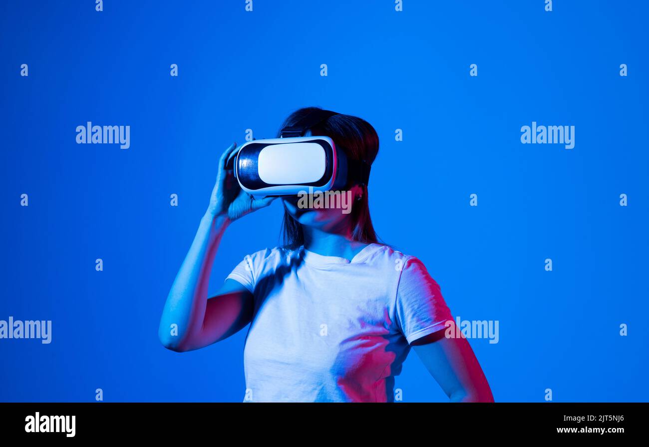 Young woman wearing VR headset while working with engineering project in lab with three dimensional printing. High tech engineering concept. Stock Photo