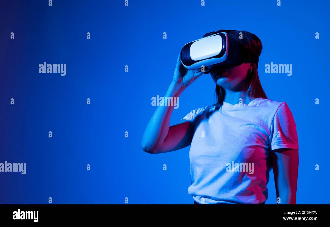 Woman in VR goggles relaxing and playing a video game with a friends in