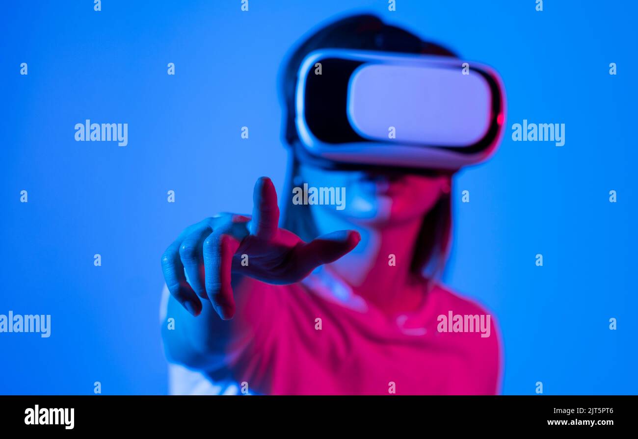 Woman in VR goggles relaxing and playing a video game with a friends in