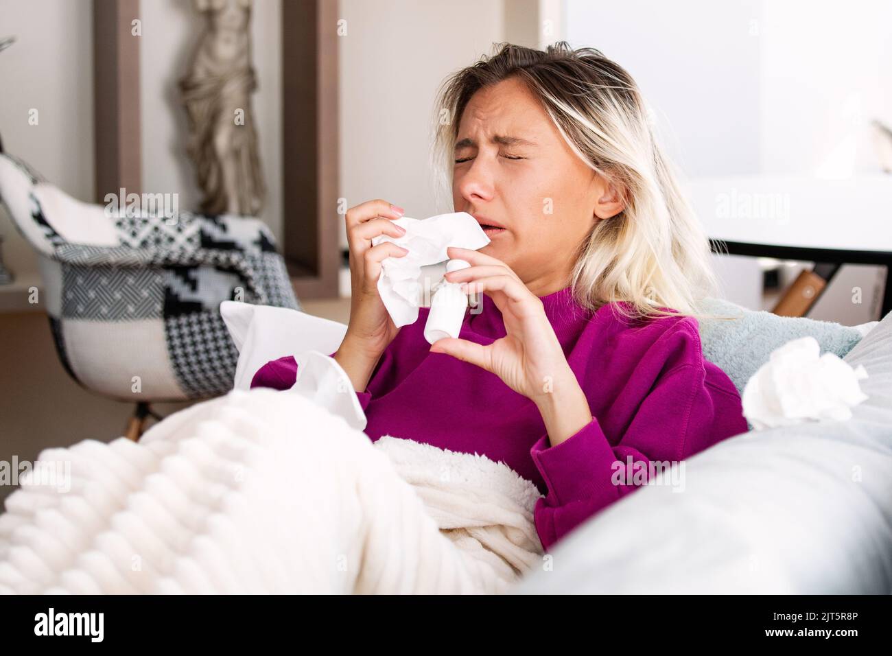 Woman is having flu and she is using nasal spray to help herself. Woman