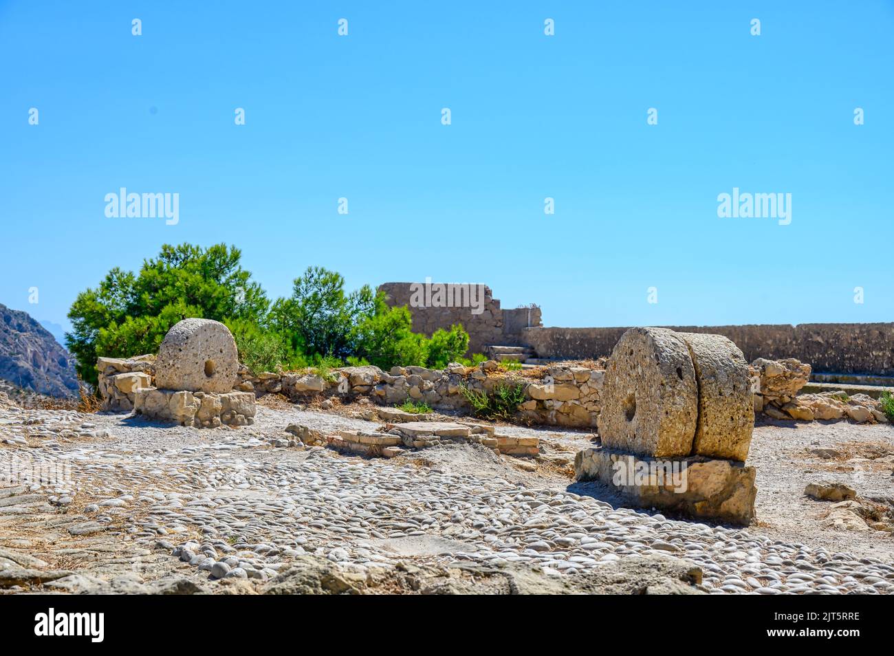Stone wheels which are remains of an old bakery. The ruined medieval fort is a major tourist attraction in the Spanish city. Stock Photo