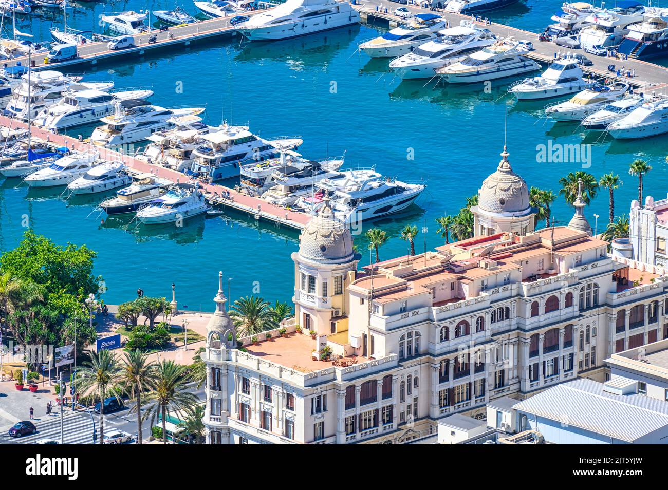 A marina with yachts. The scene includes the Casa Carbonell with its two domes or cupolas. Stock Photo
