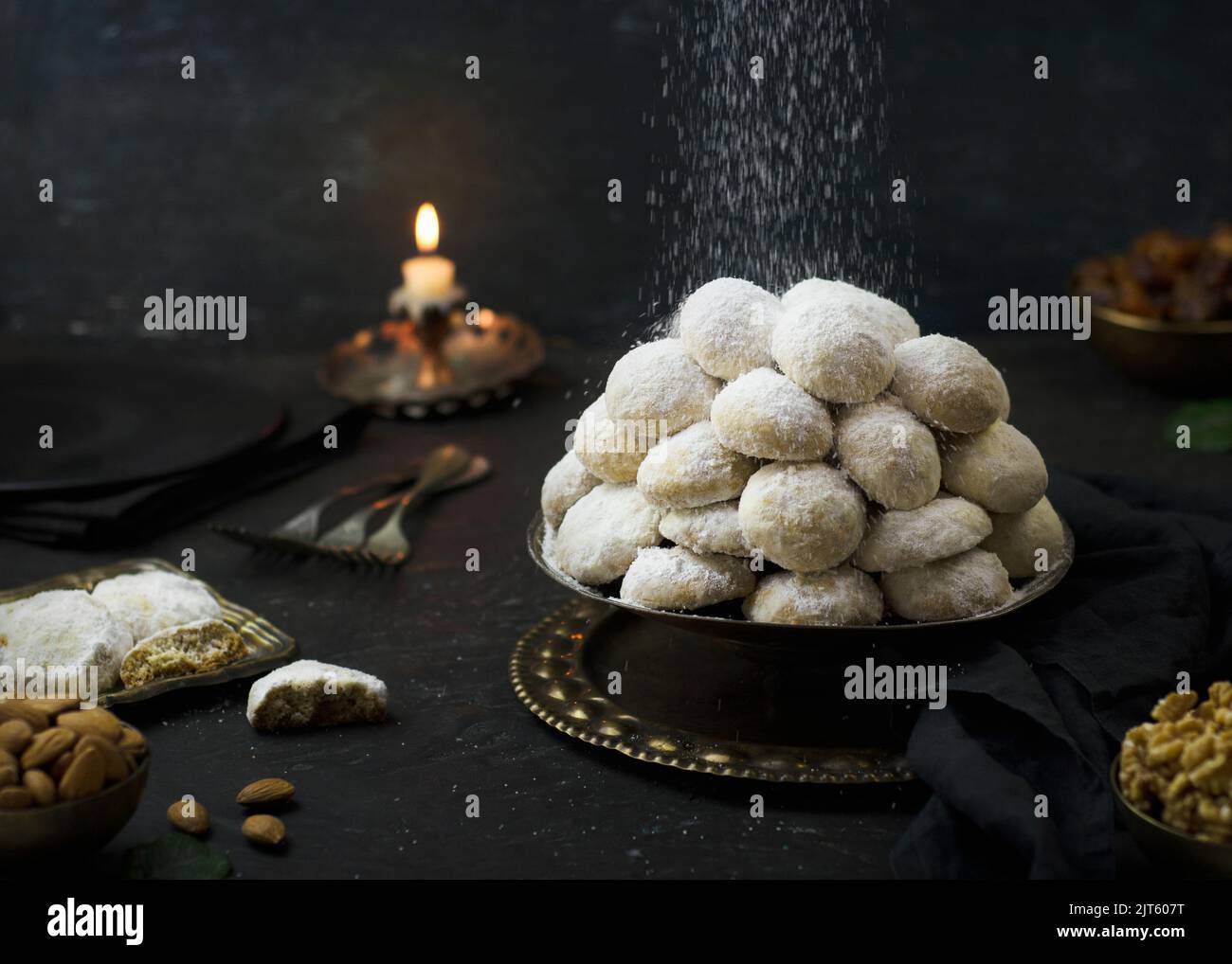 Cookies for celebration of El Fitr Islamic Feast( The Feast that comes after Ramadan).Sprinkling powdered sugar on Kahk (Eid-Al- Fitr cookies). Stock Photo
