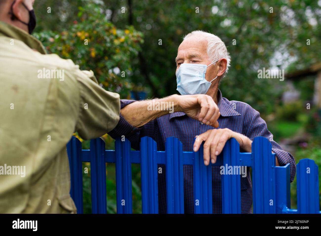 Good neighbors greet each other with touch of their elbows. Safe greeting during pandemic Stock Photo