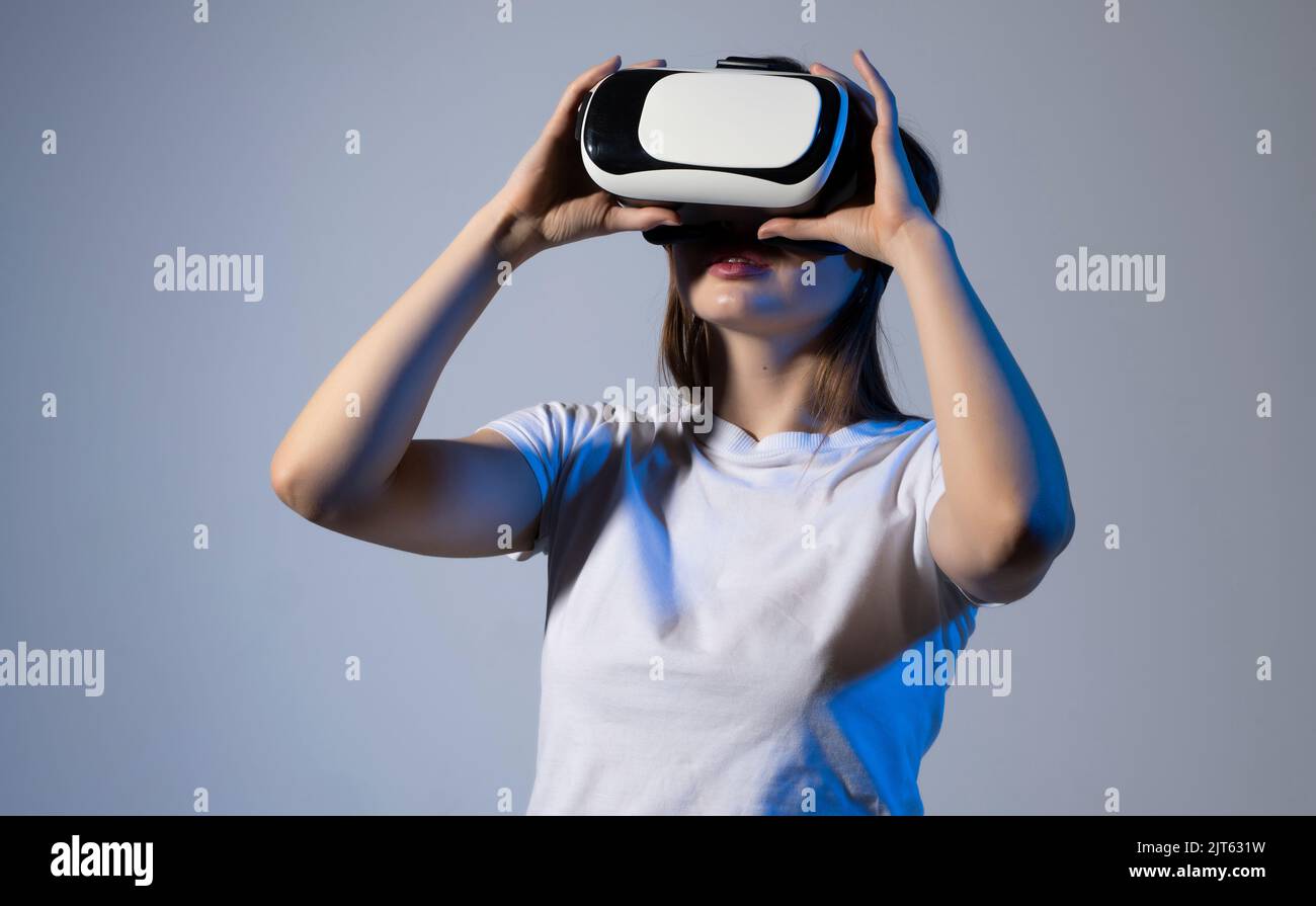 Metaverse technology concept. Woman with VR virtual reality goggles is