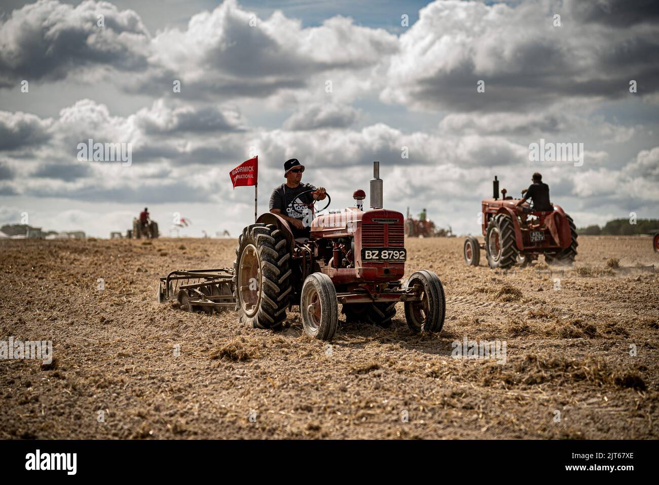Agricultural tractors work fields ploughing and raking during the Great Dorset Steam Fair at