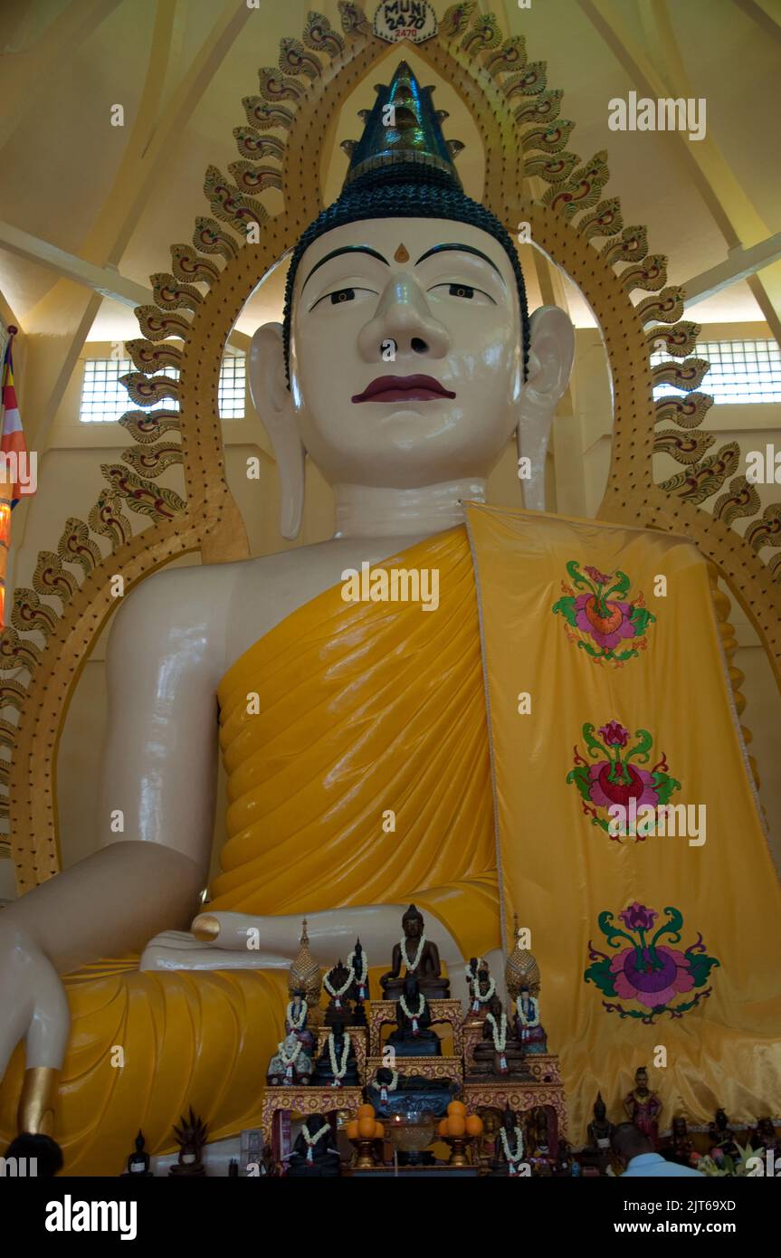 Statue of the Buddha, Sakya Muni Buddha Gaya Buddhist Temple, Little India, Singapore.  Large seated Buddha with orange robes. Stock Photo