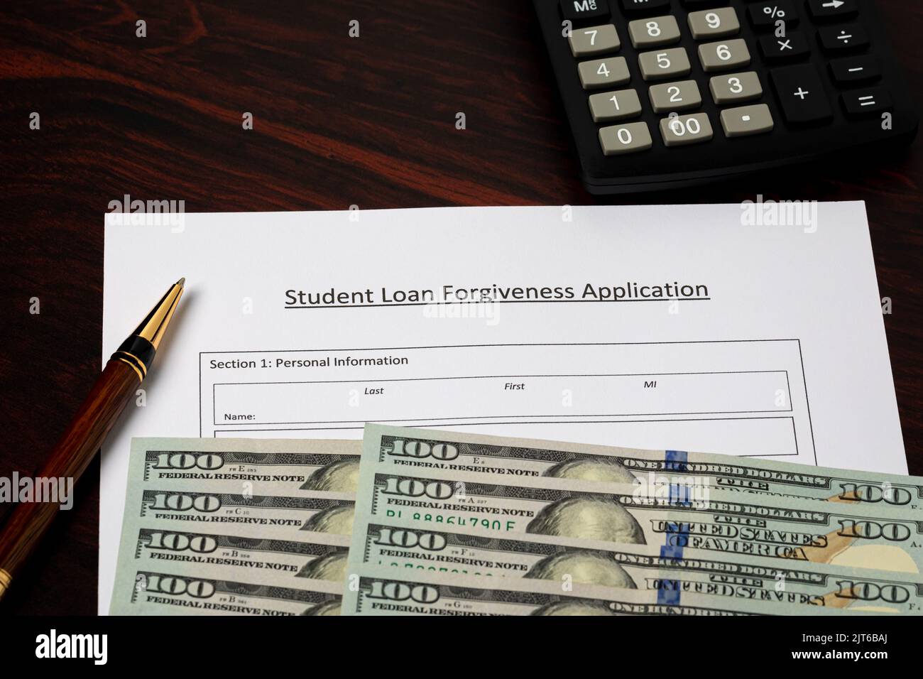 Student loan forgiveness application with cash money. Student debt crisis, tuition assistance and financial aid concept. Stock Photo